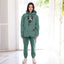 Person wearing a emerald hoodie and pants with a dog, standing in a bright room.