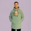 Person wearing a light green hoodie with a dog peeking out of the front pocket against a purple background