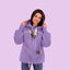 Person wearing a purple hoodie with a small dog on a white background