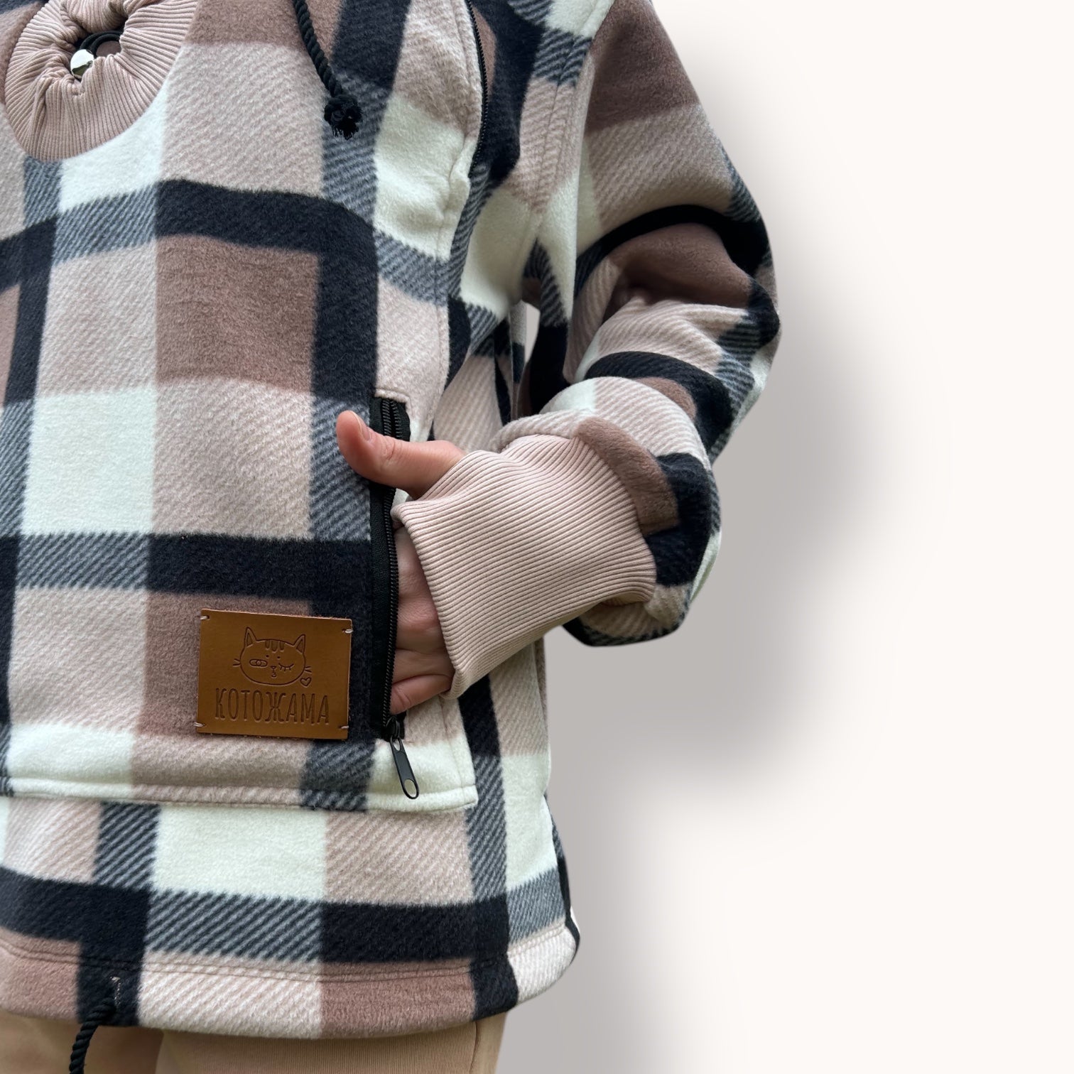 Plaid-patterned coat with a leather patch on a light background