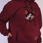 Maroon hoodie with a cat face design on the chest pocket against a plain background