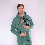 Person wearing a Emerald Green hoodie with a cat design, holding a real cat.