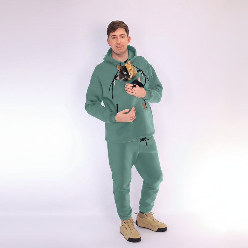 Person wearing a Emerald Green hoodie and pants with a unique design, holding a cat. Main image