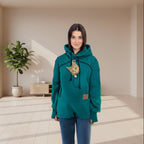 Person wearing a teal  Forest Green hoodie with a cat design on a white background