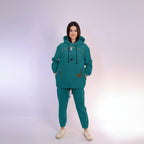 Person wearing a teal tracksuit on a white background