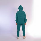 Teal tracksuit worn by a person on a white background