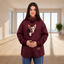 Person wearing a burgundy sweatshirt with a cat in an indoor setting