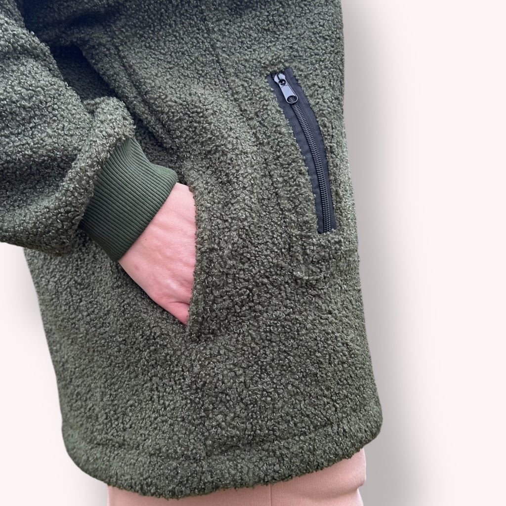Khaki fleece hoodie with a zipper pocket on a neutral background