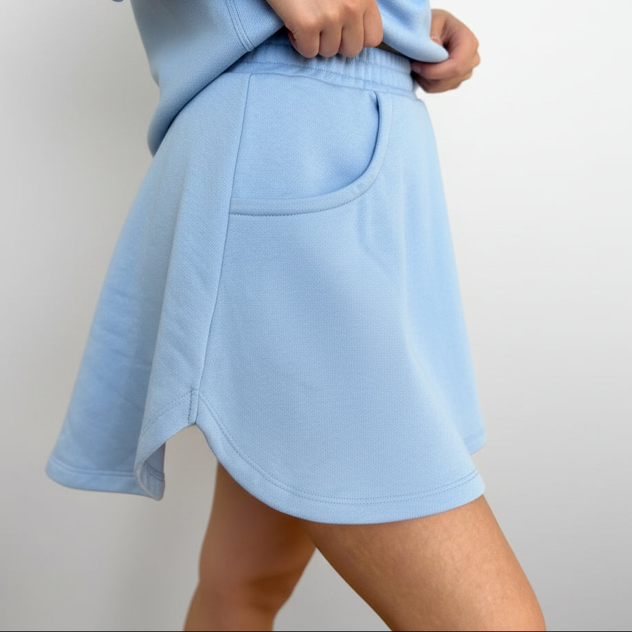 Light blue skirt worn by a person on a plain background