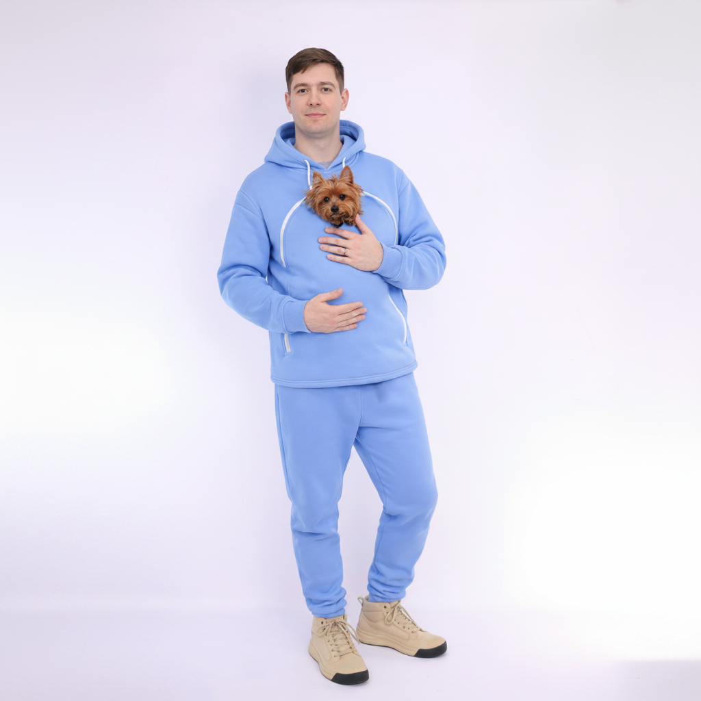 Man wearing a Light Blue tracksuit holding a small dog on a white background