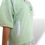 Lime green top with a zipper pocket on a white background