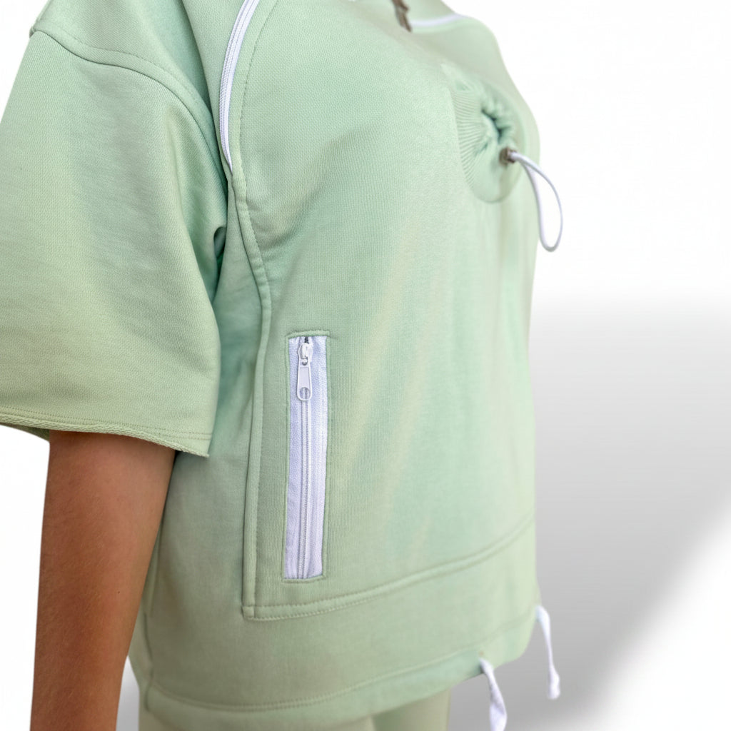Lime green top with a zipper pocket on a white background