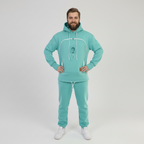 Man wearing a mint green tracksuit on a white background