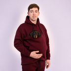 Person wearing a Red Burgundy hoodie with a dachshund face design on a light gray background