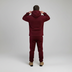 Person wearing a Red Burgundy tracksuit on a white background