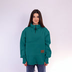 Person wearing a teal sweatshirt with a brown patch on a white background