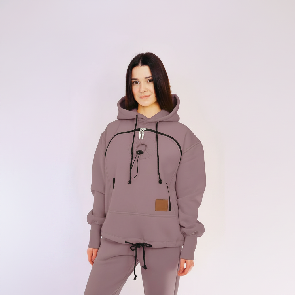Person wearing a mauve hoodie and pants set on a white background