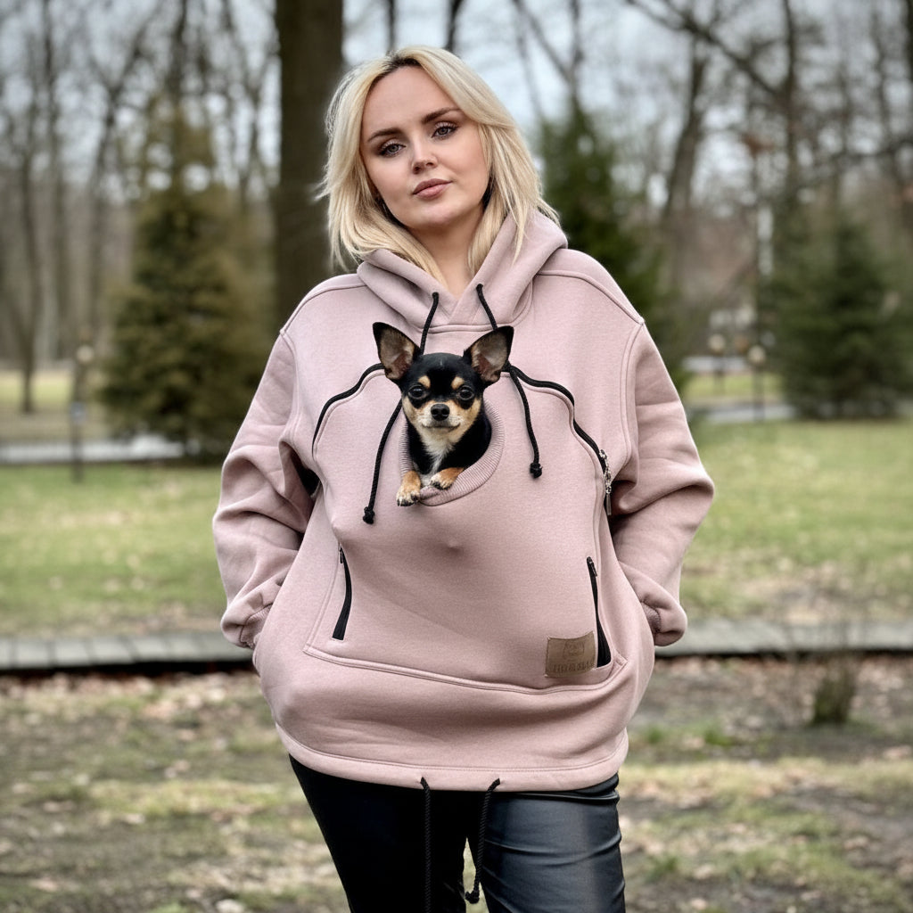 Person wearing a beige hoodie with a dog graphic outdoors