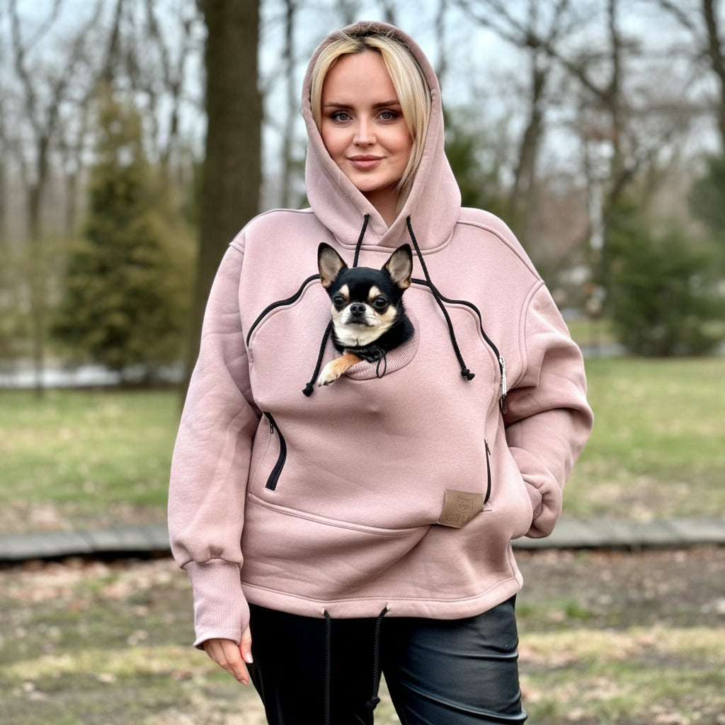 Person wearing a beige hoodie with a dog graphic outdoors
