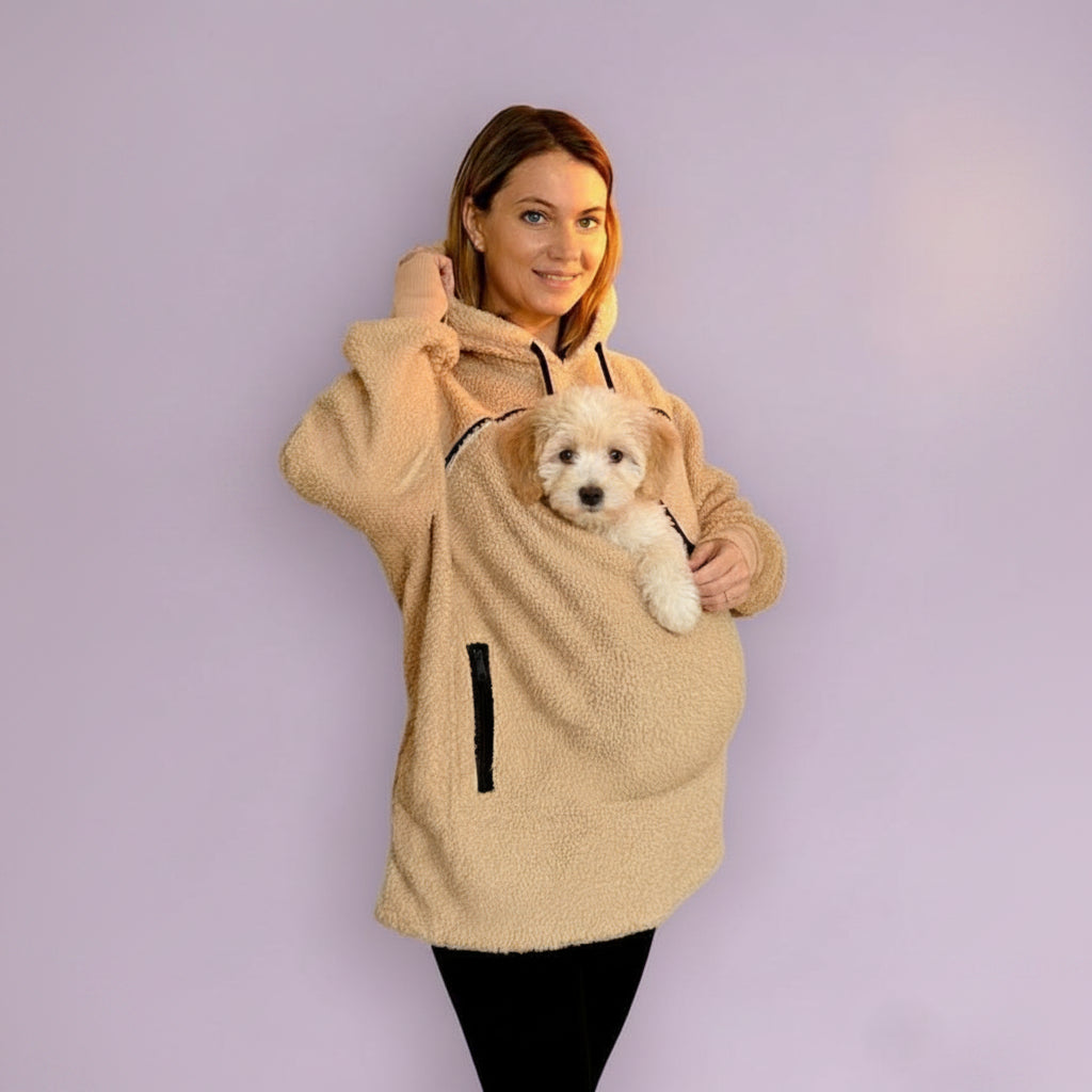 Person wearing a beige boucle hoodie with a front pocket, holding a small dog.