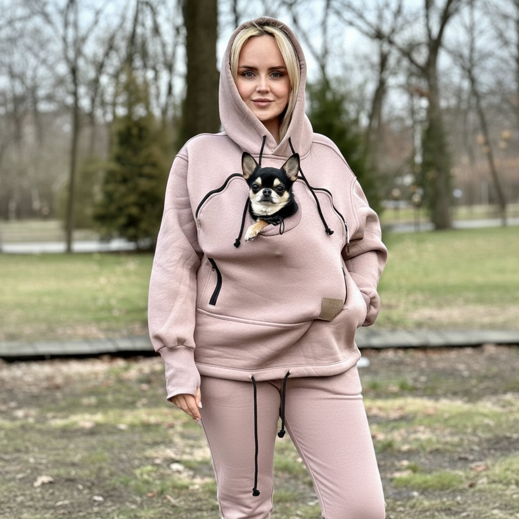 Person wearing a beige hoodie with a dog outdoors Main image