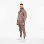 Man wearing a brown tracksuit on a white background