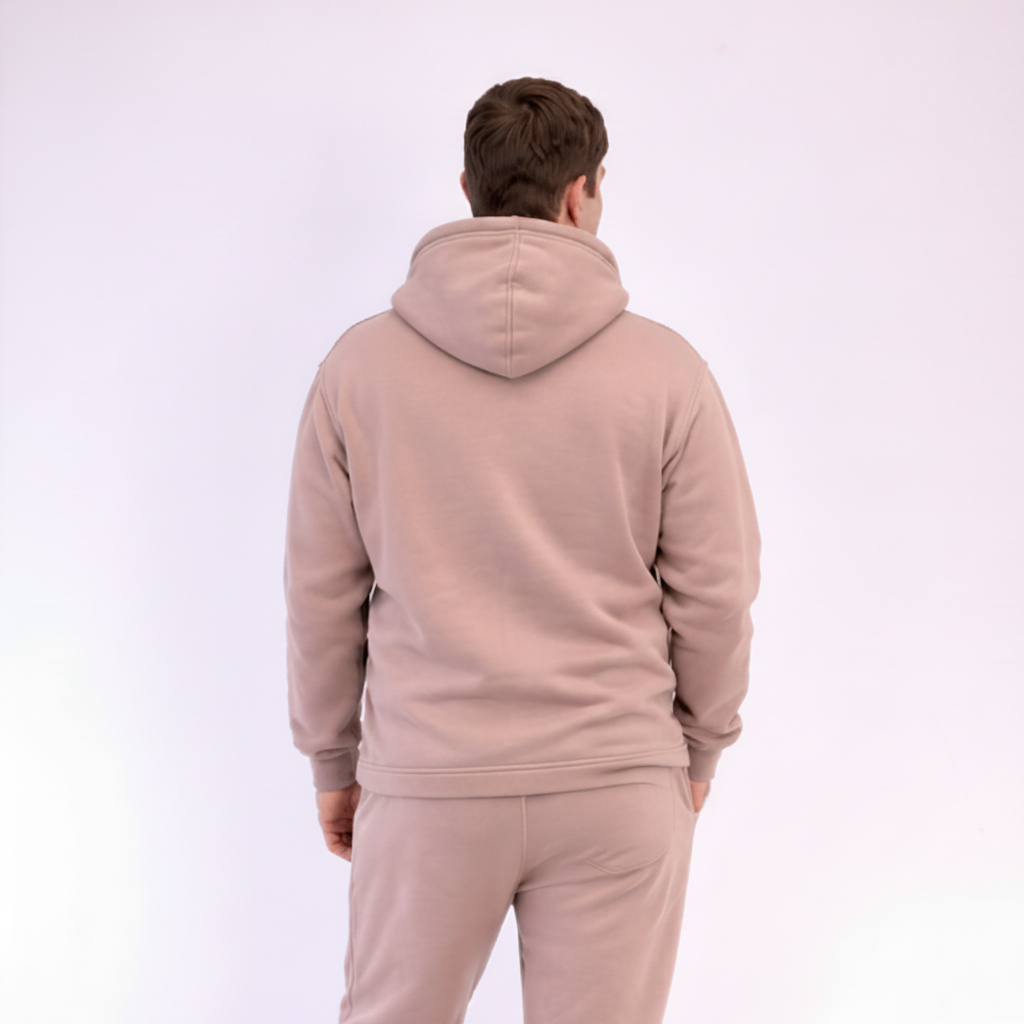 Person wearing a beige tracksuit on a white background