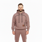 Man wearing a brown tracksuit with a hoodie on a white background