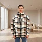 Man wearing a plaid sweatshirt with a cat in a pouch in a living room