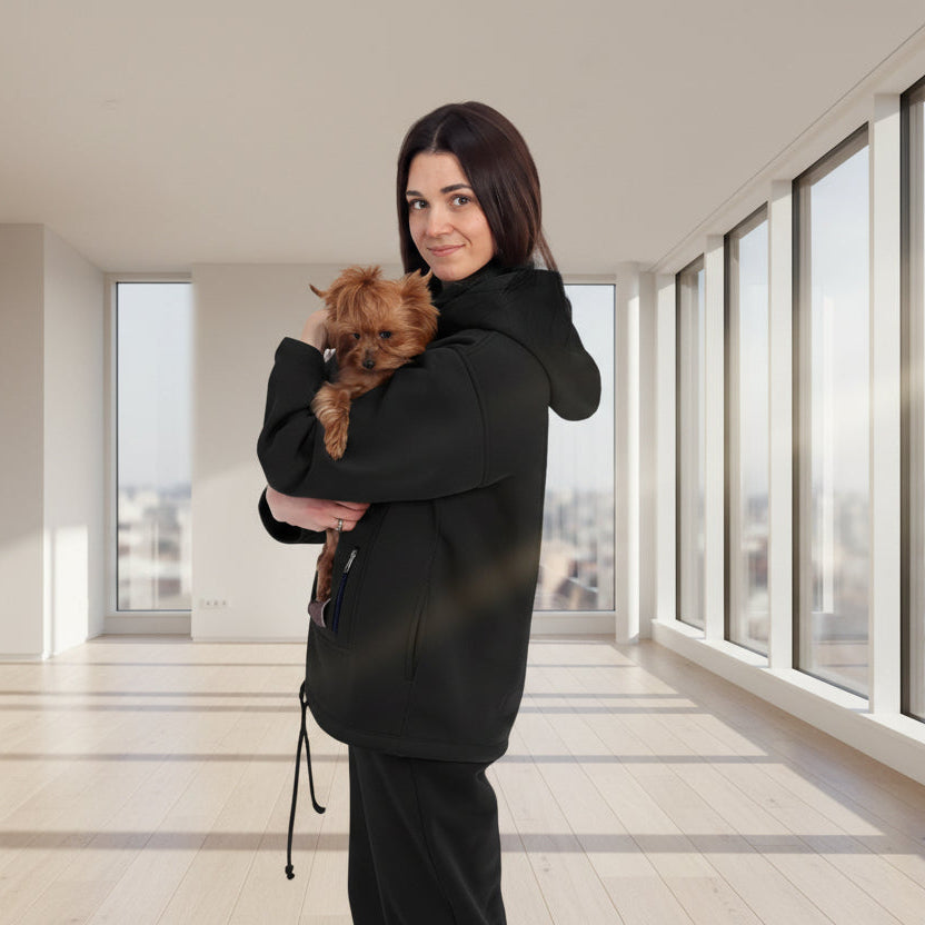 Woman in black tracksuit holding a small dog in a white room with plants. Основне зображення