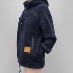 Black boucle fleece pullover with a brand patch on a gray background