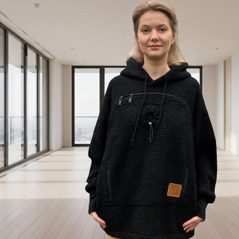 Woman wearing a black boucle  hoodie standing in a room