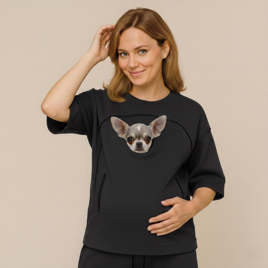 Woman wearing a black sweatshirt with a dog's face on it against a beige background