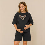 Woman wearing a black outfit with a dog on a beige background