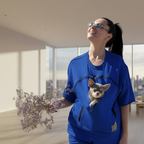 Person wearing a blue shirt with a dog in a modern living room.