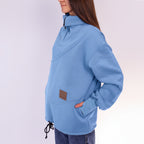 Person wearing a blue pullover with a brown patch on a white background
