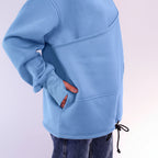 Light blue hoodie worn by a person with a plain background