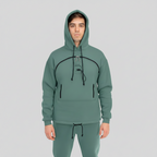 Person wearing an emerald hoodie and pants set on a white background