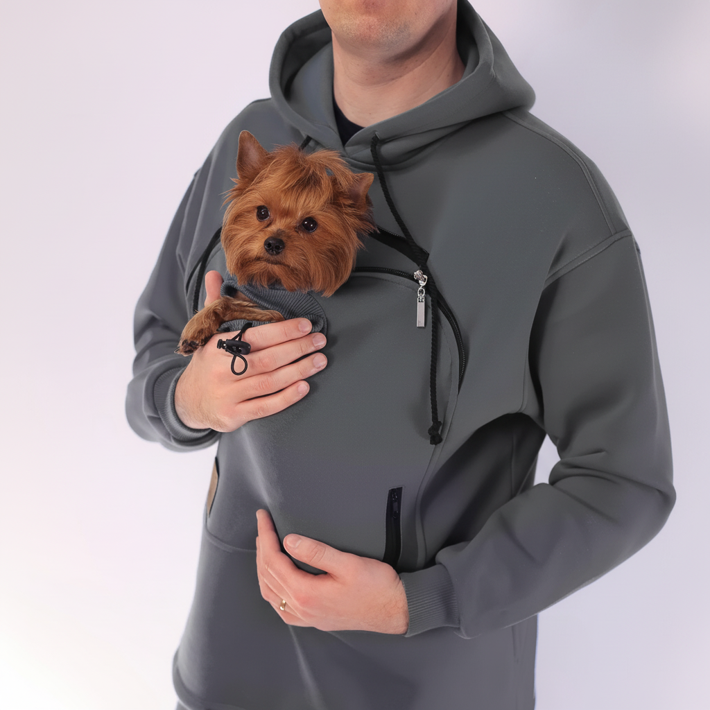 Person wearing a gray hoodie with a front pocket holding a small brown dog.