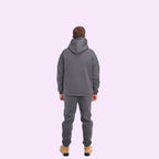 Person wearing a gray tracksuit on a white background
