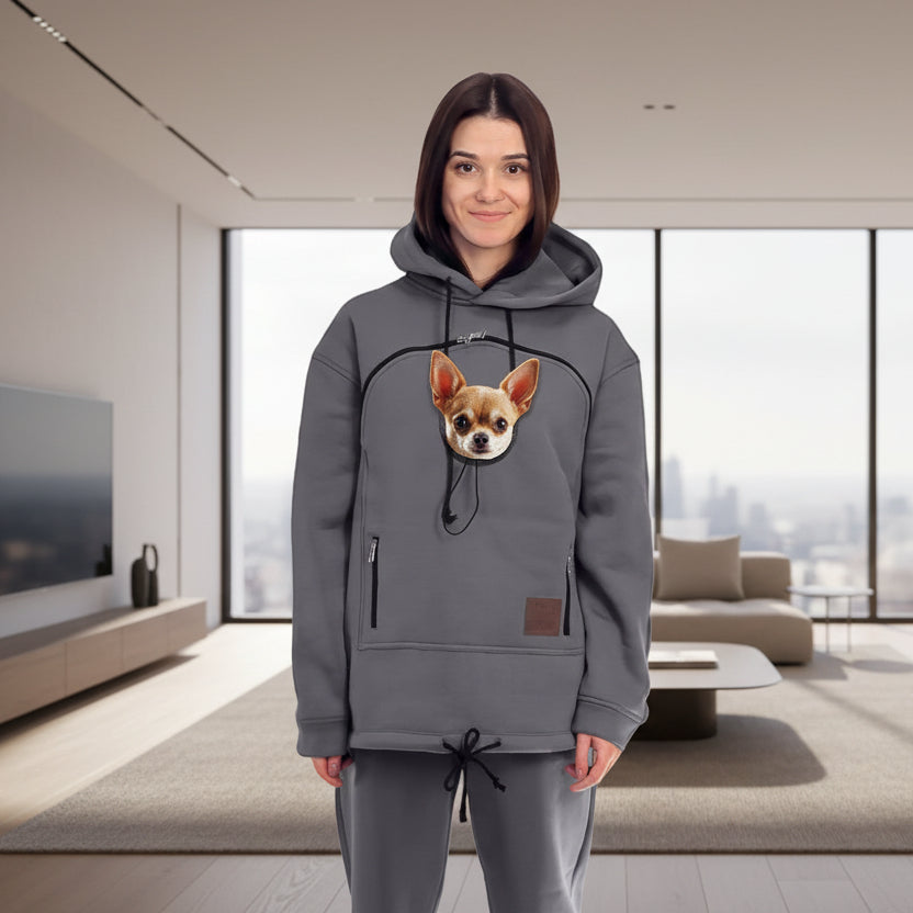 Women wearing a gray hoodie with a dog and matching pants in a minimalistic room. Main image