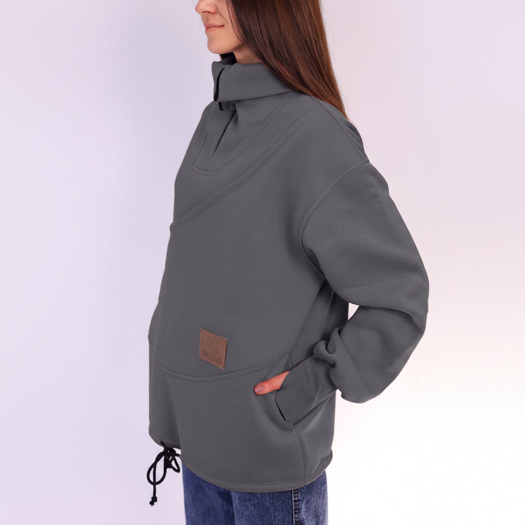 Person wearing a gray pullover with a brown patch on a white background
