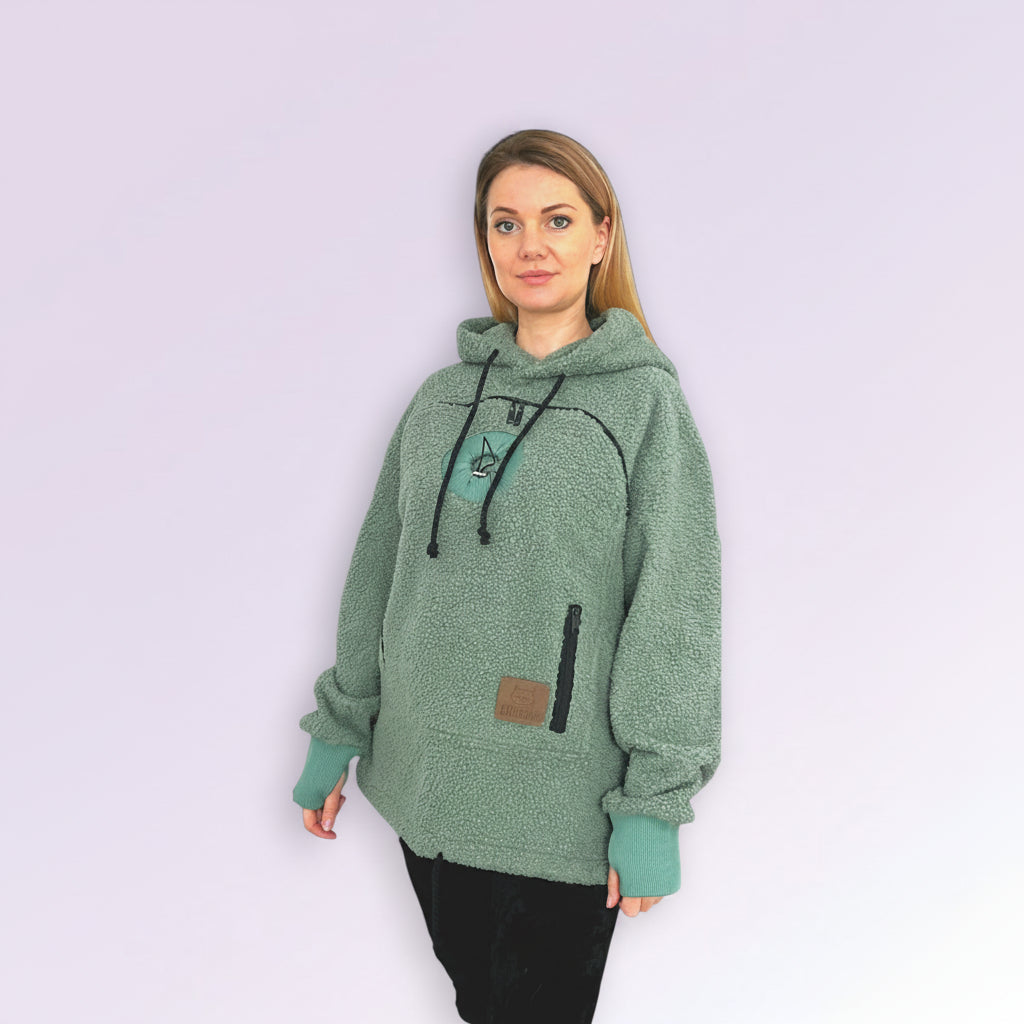 Woman wearing a green hoodie with a logo on a white background