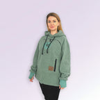 Woman wearing a green hoodie with a logo on a white background