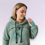 Woman wearing a green fleece hoodie with a white background