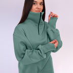 Woman wearing a green high-neck sweater against a white background