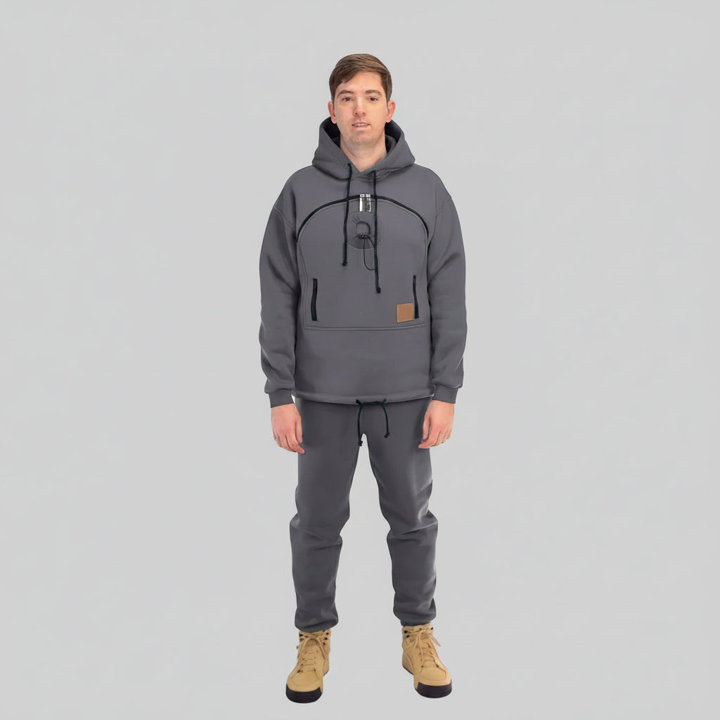 Person wearing a gray hoodie and pants with a white background