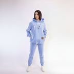 Woman wearing a light blue hoodie and pants on a white background