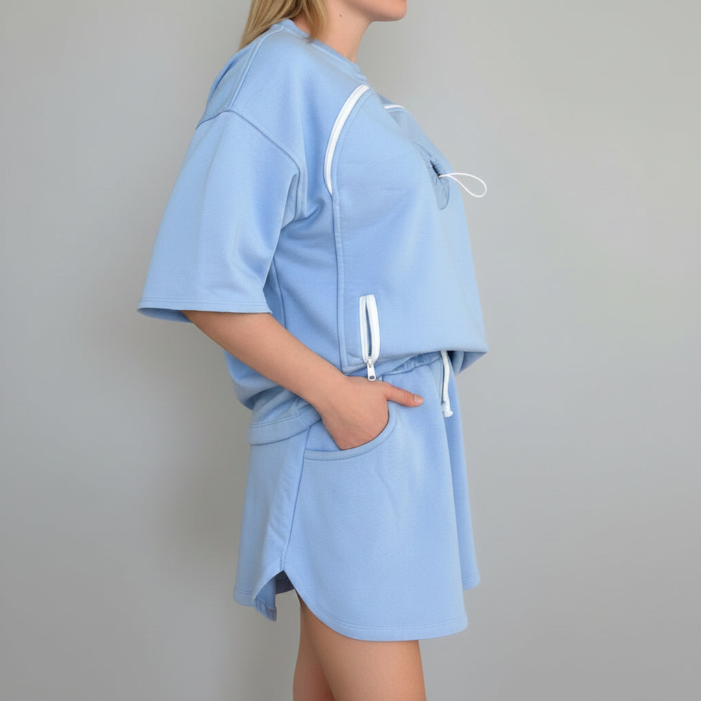 Light blue outfit with white zippers on a plain background