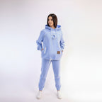 Woman wearing a light blue hoodie and pants on a white background